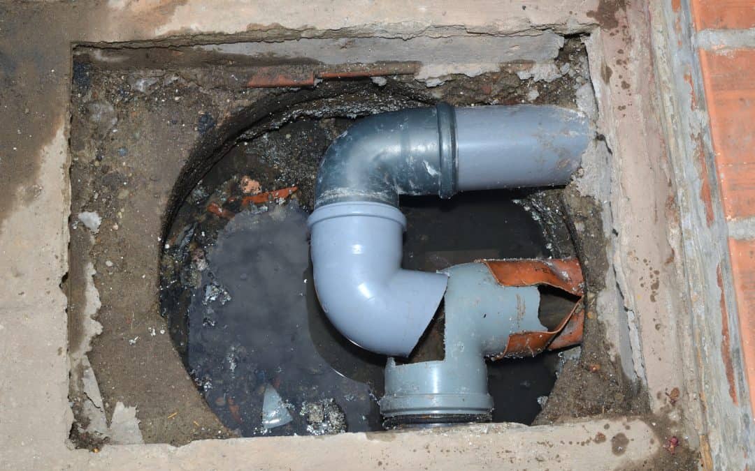 A broken pipe with u-bend in a cellar